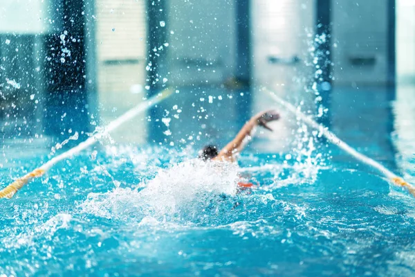 Nadador profesional haciendo ejercicio en piscina cubierta — Foto de Stock