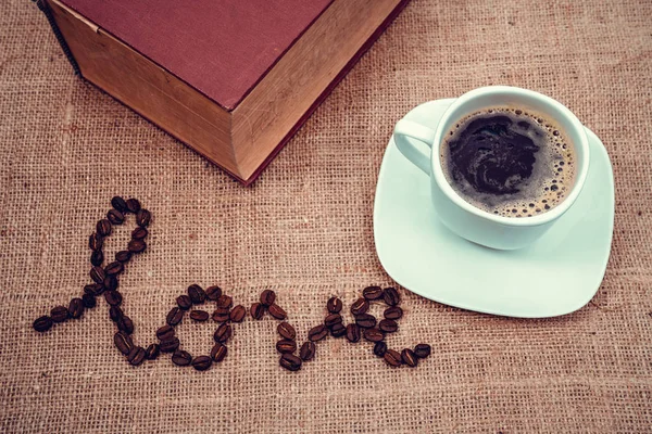 Una imagen vintage para mostrar el amor con granos de café y una taza de cofee . —  Fotos de Stock