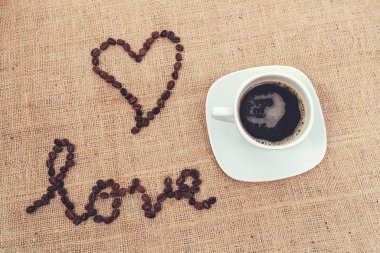 Aşkı kahve çekirdekleri ve bir fincan kahveyle göstermek için klasik bir görüntü..