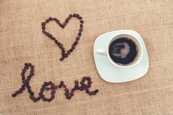 Aşkı kahve çekirdekleri ve bir fincan kahveyle göstermek için klasik bir görüntü.. — Stok fotoğraf