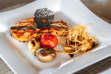 Lezzetli bir kızarmış somon balığı şık bir restoranda ya da otelde servis edilir.