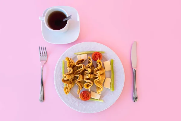 stock image Tea time, cup of freshly brewed tea, warm soft and light and as aperatif plate of crepe with pink background