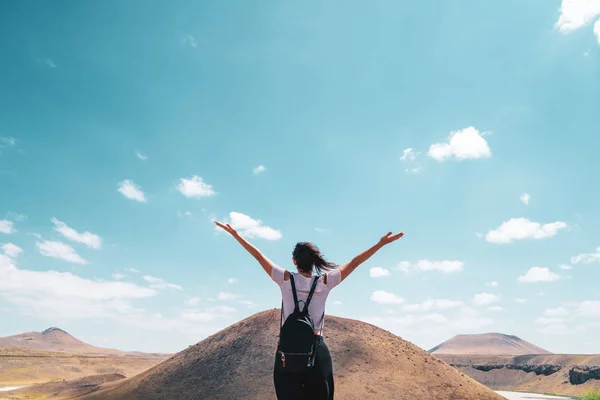 Femme est debout devant une colline avec les bras grands ouverts — Photo