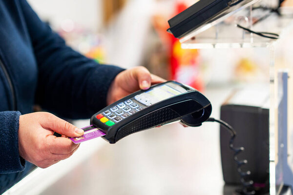 Close up of cashier is using credit card pos terminal to getting the payment. 