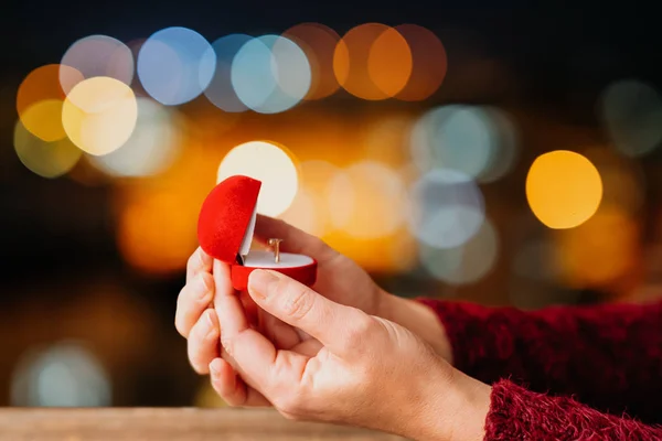 Nainen avaa lahjapakkauksensa koruja bokeh led valot tausta. Ystävänpäivä ja romanssi käsite . — kuvapankkivalokuva