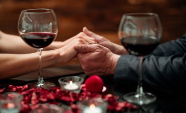 Güzel dekorasyonlu şık bir restoranda romantik bir akşam yemeği yiyen bir çift. Romantizm ve Sevgililer Günü konsepti. 