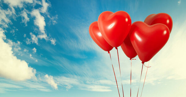 Group of heart shaped red air baloon on blue sky with clouds. Valentines day and romance concept.