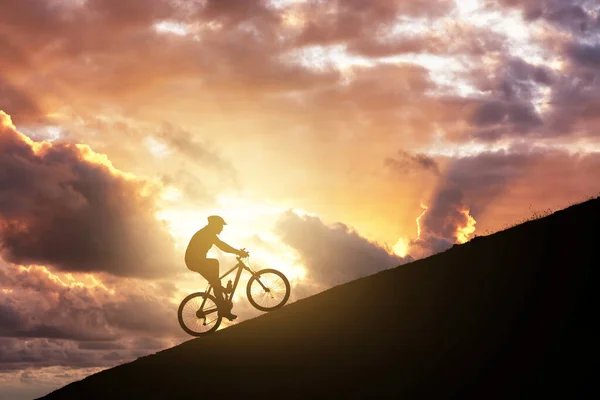 Mountainbike fahren auf einer Rampe gegen bewölkten Himmel. Erreichen des Schwierigkeits- und Verbesserungskonzepts. — Stockfoto
