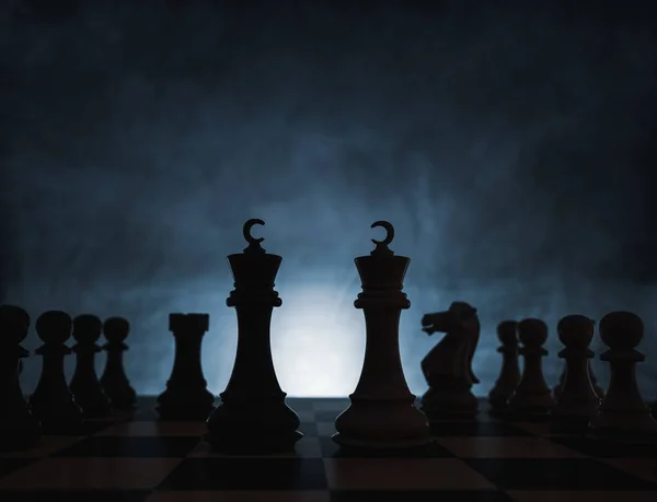 Conceito de jogo de xadrez de desafio, ideias e competição. Figuras de xadrez isoladas com fundo escuro com nevoeiro e luz branca . — Fotografia de Stock