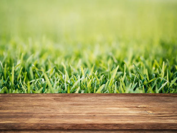 Schöne Frühling Hintergrund mit grünem Laub und leeren Holztisch in der Natur im Freien. Natürliche Vorlage mit Sonnenlicht. — Stockfoto