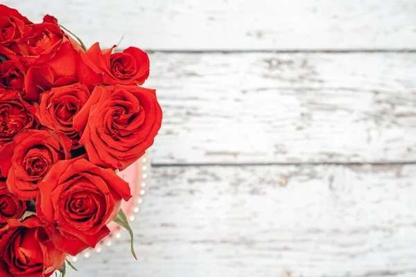 Ein Strauß scharlachrote Rosen für den Valentinstag Schmuck Konzept mit weißem Holzhintergrund. Konzept Liebe und Romantik. — Stockfoto