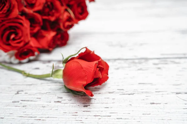 A bouquet of scarlet roses for Valentines day ornaments concept with white wooden background. Love and romance concept. Stock Photo