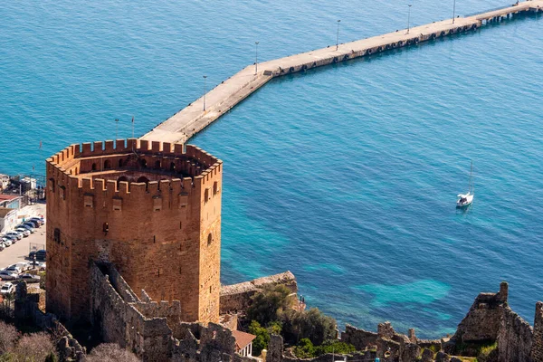 A történelmi romok a piros torony és várfalak mellett kikötő város Alanya Antalya tartományban. — Stock Fotó