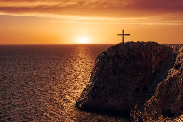 Vedere aeriană a unui crucificator pe marginea unei stânci împotriva mării și apusului de soare . — Fotografie, imagine de stoc