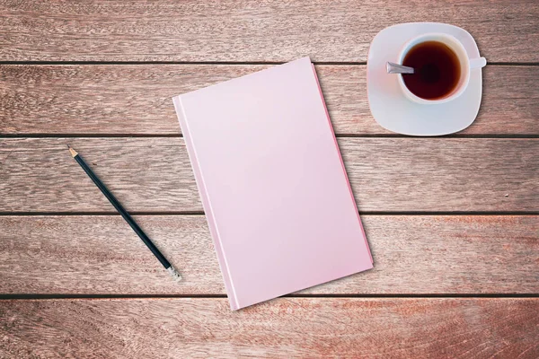 Lápiz y un cuaderno cubierto de color rosa en la mesa de madera. Vista de pájaro, concepto de maqueta . — Foto de Stock