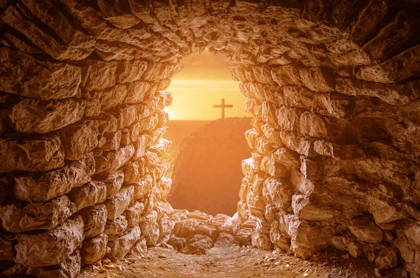 Uma silhueta de um túmulo com Crucifixo fora das paredes contra o pôr do sol . — Fotografia de Stock