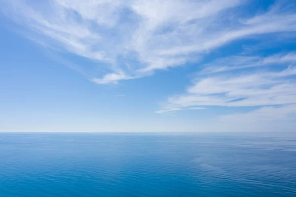 Eine Luftaufnahme des ewig blauen Meeres oder Ozeans mit sonnigem und bewölktem Himmel. — Stockfoto