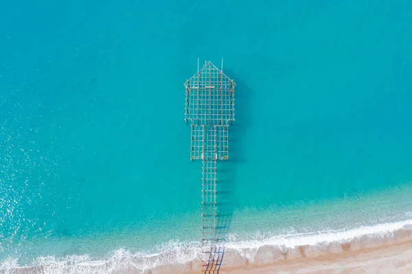 Veduta aerea di onde marine turchesi e spiaggia sabbiosa e un molo in costruzione, Turchia, Antalya . — Foto Stock