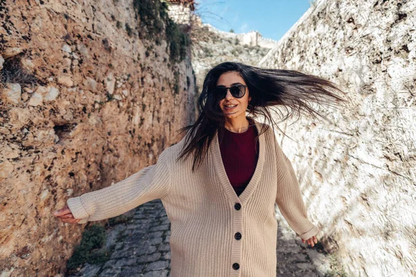 Mujer joven está caminando con felicidad entre las paredes históricas en un callejón estrecho. Concepto Turismo y Viajes . — Foto de Stock