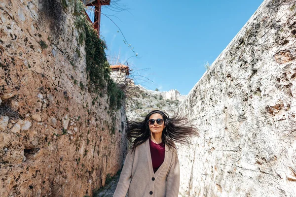 Молодая женщина ходит со счастьем между историческими стенами по узкому переулку. Концепция туризма и путешествия . — стоковое фото