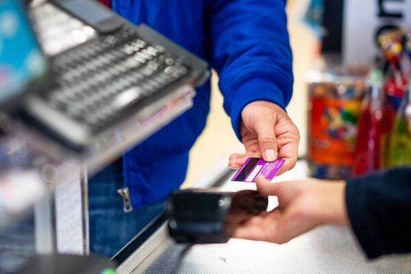 Close up of using credit card pos terminal to pay. Hands inserting the creditcard to pos terminal for payment.