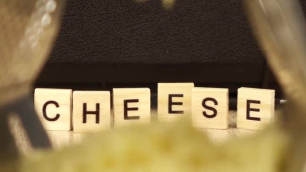 The camera moves away from the inscription cheese through a metal grater — ストック動画