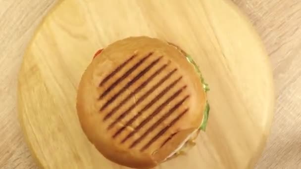 Hamburguesa giratoria en un soporte de madera vista superior — Vídeos de Stock