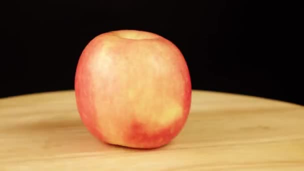 Червоне яблуко обертається на 360 градусів на дерев "яній підставці. — стокове відео