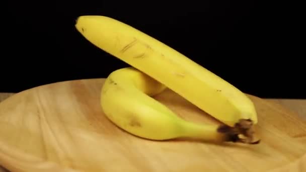 2 банана вращаются на 360 градусов на деревянном подставке — стоковое видео