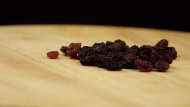 Bir avuç kuru üzüm siyah zemin üzerinde 360 derece döner. — Stok video