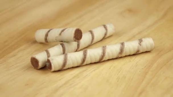 Três tubos de bolacha giram 360 graus em um suporte de madeira — Vídeo de Stock