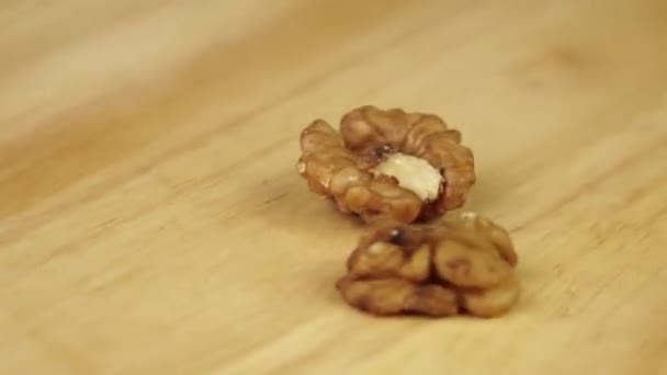 Een pakje walnoten draait 360 graden op een houten statief — Stockvideo