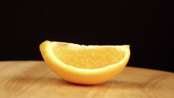 オレンジのスライスは木製のプラットフォーム上で360度回転します — ストック動画
