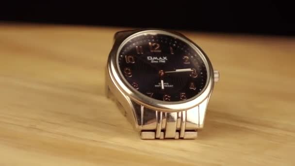 Die silberne mechanische Uhr dreht sich um 360 Grad auf einer Holzplattform — Stockvideo