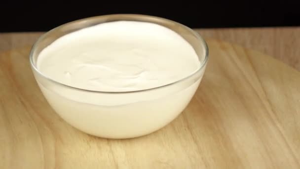 В миске с йогуртом разливая различные орехи — стоковое видео