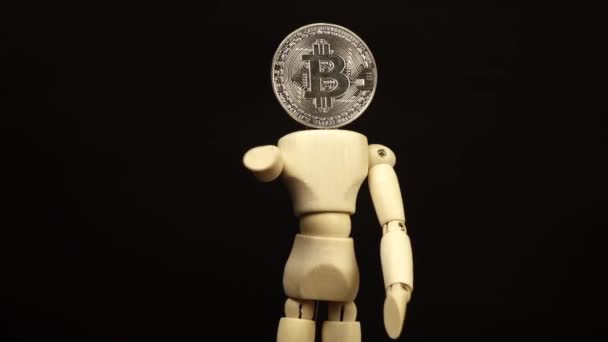 Boneca de madeira com uma cabeça na forma de uma bitcoin gira 360 graus — Vídeo de Stock