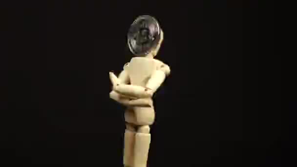Holzpuppe mit Kopf in Form einer Bitcoin-Münze dreht sich auf schwarzem Hintergrund um 360 Grad — Stockvideo