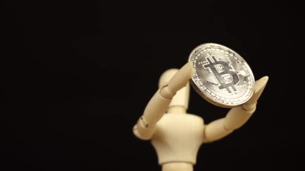 Holzpuppe mit Kryptowährung Bitcoin auf schwarzem Hintergrund — Stockvideo