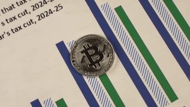 Bitcoin perak terletak di atas kertas dengan grafik — Stok Video