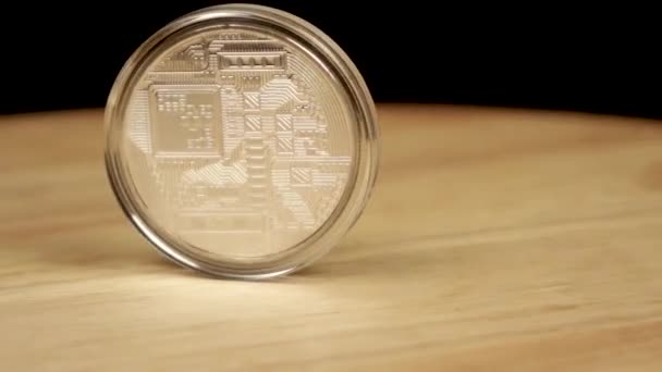 Биткойн серебряной монеты вращается на 360 градусов на деревянной платформе — стоковое видео