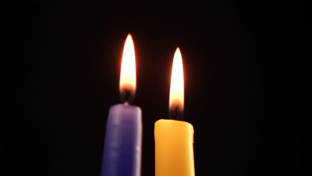 Candele blu e gialle che bruciano su uno sfondo nero — Video Stock