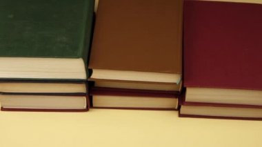 Bir erkeğin eli kitapları teker teker kaldırır.