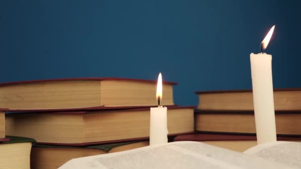 Mano pone libros sobre la mesa con velas y un libro principal — Vídeos de Stock