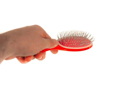 El, izole edilmiş beyaz arkaplanda bir tarak tutuyor