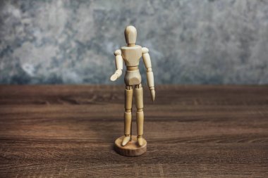 Tahta heykel elini öne çekiyor. Yalvarma konsepti.