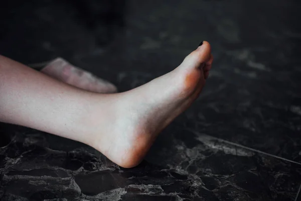 Womens little leg against the background of the marble floor — Stock Photo, Image