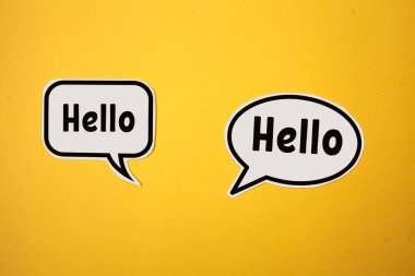 Üzerinde yazı olan iki beyaz bulut. Sarı arkaplanda merhaba yazıyor..