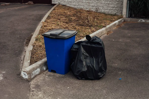 Bidone della spazzatura blu in piedi sulla strada — Foto Stock
