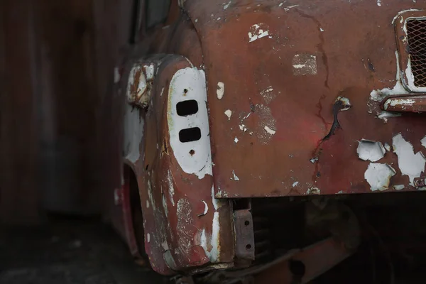 an old abandoned car standing in a car cemetery