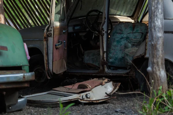 Um velho e enferrujado carro abandonado com as portas abertas — Fotografia de Stock